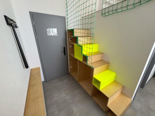 a staircase in a room with yellow and green steps at ROCH800 - industriální aparthotel Klatovy in Klatovy