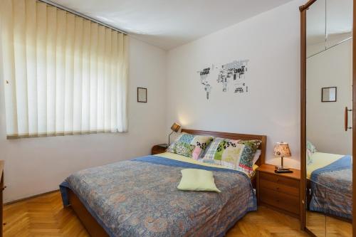 a small bedroom with a bed and a mirror at Apartments Ružić in Split