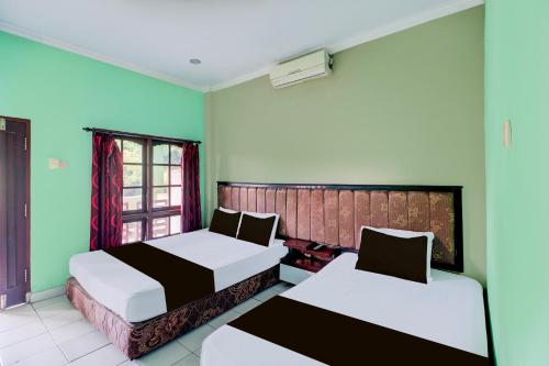 Ένα ή περισσότερα κρεβάτια σε δωμάτιο στο Collection O Bali near Terminal Ubung formerly Batukaru Garden Hotel