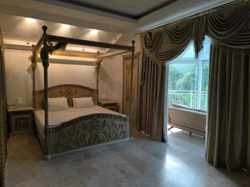 a bedroom with a canopy bed and a balcony at Amazonica MAGİC DREAM in Kemer