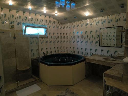 a bathroom with a tub and two sinks and a shower at Amazonica MAGİC DREAM in Kemer