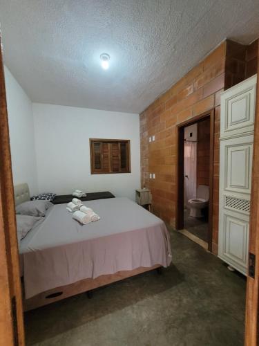 a bedroom with a bed and a bathroom with a toilet at Chácara La Belle de Jour in Piedade
