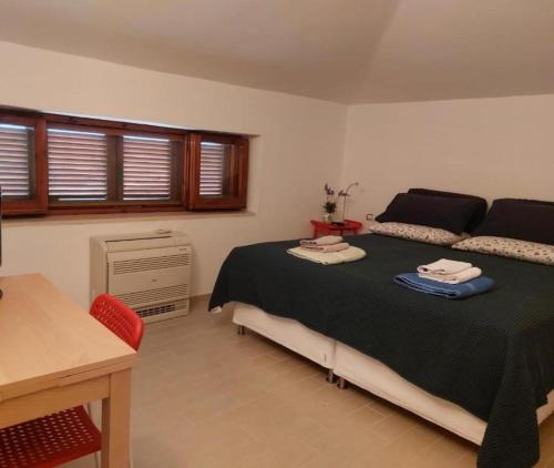 a bedroom with a bed and a desk and window at La Quercia in Altavilla Silentina