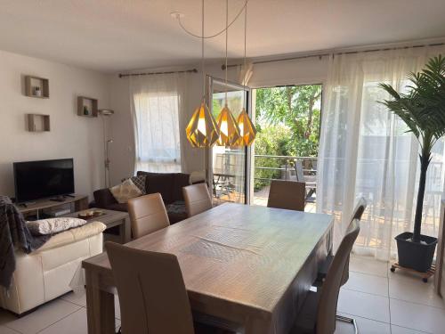 - un salon avec une table à manger et un canapé dans l'établissement Villa moderne et familliale dans une résidence à 500m de la plage, à Sérignan