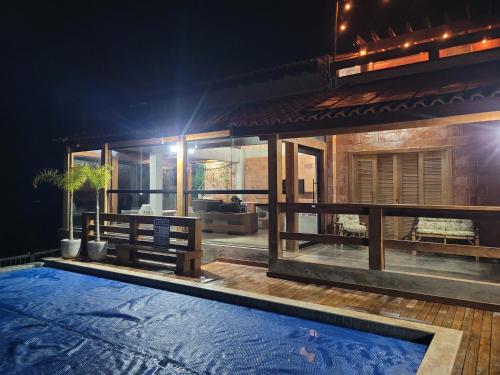 a villa with a swimming pool at night at Chácara La Belle de Jour in Piedade