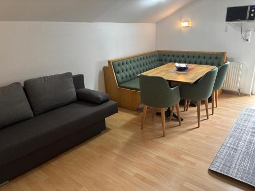 Una sala de estar con un sofá, una mesa y sillas. en Elgi Apart, en Serfaus