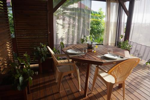 una mesa de madera y sillas en una terraza en Caraibe Créol' Keys, en Port-Louis