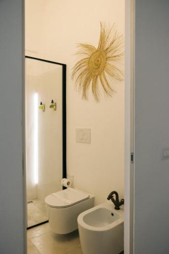 a bathroom with a toilet and a sink and a mirror at Corte Manfredi in Alessano