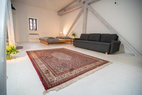 a living room with a couch and a rug at PENZION "Pivovar" KLUGE - Jedinečné ubytování v areálu bývalého pivovaru in Rudník