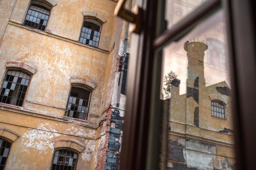 a window view of a building and a tower at PENZION "Pivovar" KLUGE - Jedinečné ubytování v areálu bývalého pivovaru in Rudník