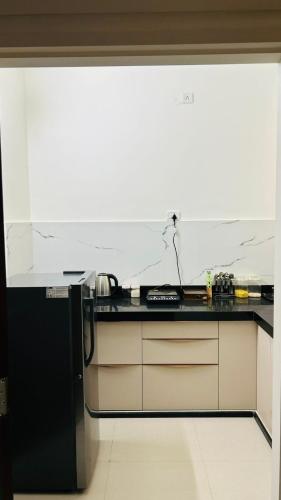 a kitchen with a black and white counter top at Thamosa Stays in Jaipur