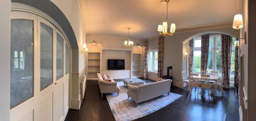 a living room with a couch and a tv at Berthlwyd Country House in Conwy
