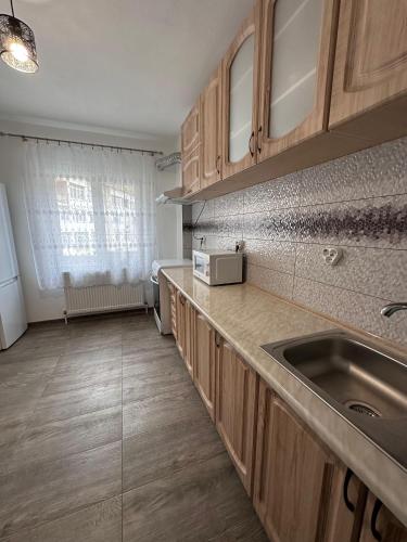 a kitchen with wooden cabinets and a sink at Cazare Herculane in Băile Herculane