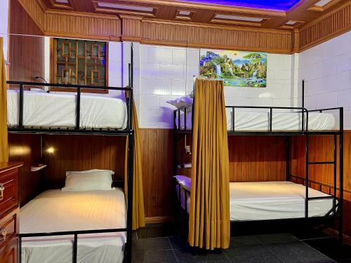 a room with two bunk beds and a ceiling at Phong Nha Tuan Garden House in Phong Nha