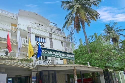 a white building with flags in front of it at HOTEL O Upasana in Bhubaneshwar