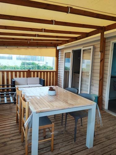 une table et des chaises en bois sur une terrasse dans l'établissement MOBILE HOME 3 CHAMBRES, à Hyères