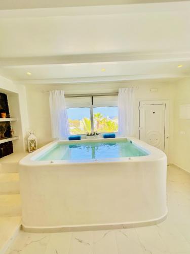 a large white tub in a room with a window at Arlene Suites in Mesaria