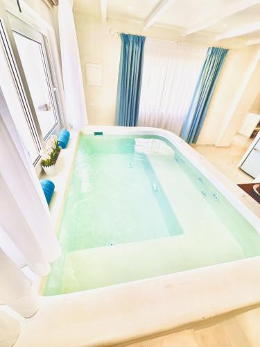 a large swimming pool in a room with a window at Arlene Suites in Mesaria