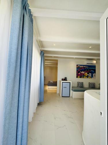 a hallway with blue curtains and a room with a bed at Arlene Suites in Mesaria