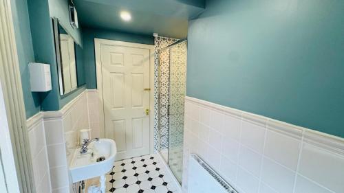 a bathroom with a white sink and a shower at Berthlwyd Country House in Conwy