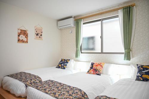 a room with two beds and a window at Umeda Yodogawa Cozy Home 101 步行到JR站5分钟 直达京都神户 大阪梅田1站 新大阪2站 USJ地铁25分钟 in Osaka
