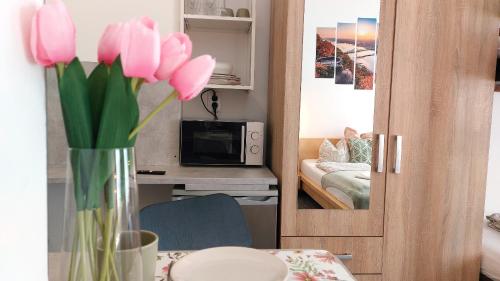 un vase de tulipes roses assis sur une table dans l'établissement GoodMo Budapest Smart Rooms, à Budapest