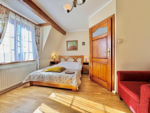 a bedroom with a bed and a red couch at Willa Tradycja in Łeba