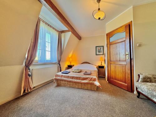 a bedroom with a bed and a wooden door at Willa Tradycja in Łeba