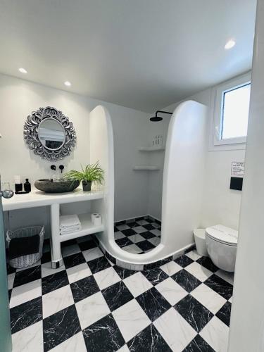 a bathroom with a black and white checkered floor at Arlene Suites in Mesaria