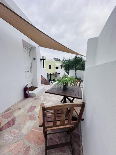 a patio with a wooden table and bench on a balcony at Arlene Suites in Mesaria