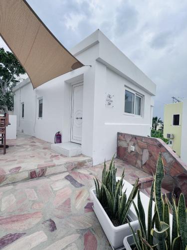 a white house with plants on a patio at Arlene Suites in Mesaria