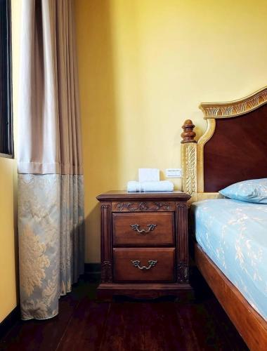 a bedroom with a bed and a wooden dresser with a wooden bed frame at 寶格儷舍 in Tainan