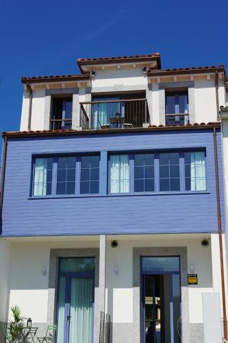 a blue and white house with a balcony at VILLAGRADO Suites in Grado