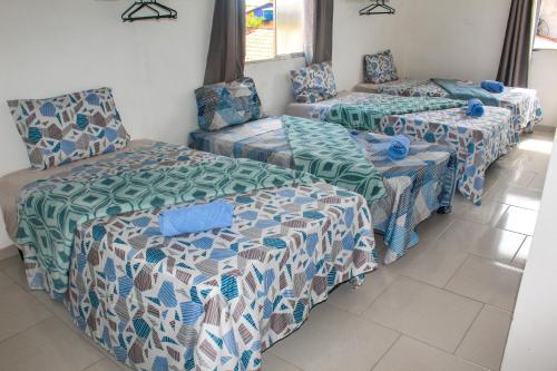 Cette chambre comprend trois lits et un canapé. dans l'établissement Pousada Areias do Mutá, à Porto Seguro