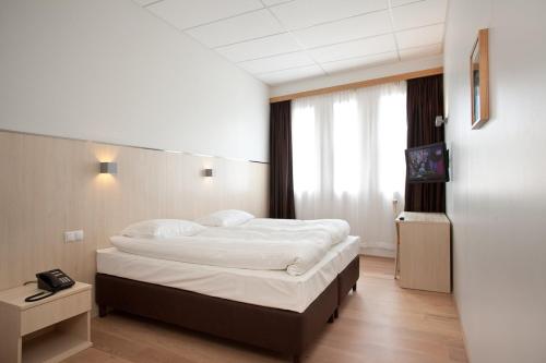 a bedroom with a large bed and a window at Hotel Klettur in Reykjavík