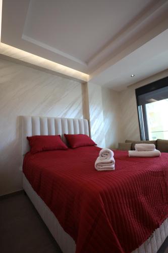 a bedroom with a red bed with two towels on it at Ornament Liman - Infinity Pool with Old Town View Apartments in Ulcinj