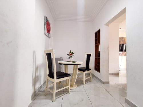 a dining room with a table and two chairs at Appartement meublé spacieux 2 chambres salon Yassa in Douala
