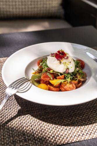 a plate of food on a table with a fork at The Y Hotel in Athens