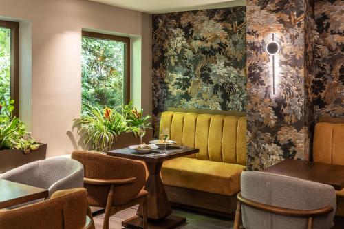 a dining room with a yellow bench and chairs at The Y Hotel in Athens