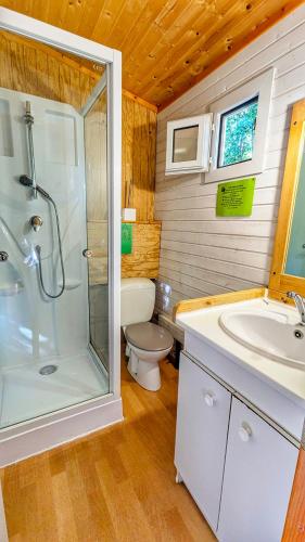 a bathroom with a shower and a sink and a toilet at Camping du lac in Saint-Julien-du-Verdon