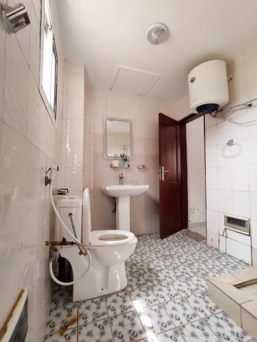 a bathroom with a toilet and a sink at Appartement meublé spacieux 2 chambres salon Yassa in Douala