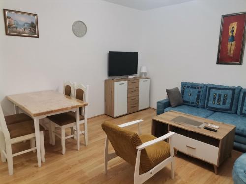 un soggiorno con un divano blu e un tavolo di Apartman Meridian a Zaječar