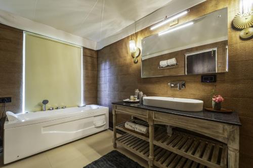 a bathroom with a sink and a bath tub at The Kablan Luxury Living Ranthambore in Sawāi Mādhopur