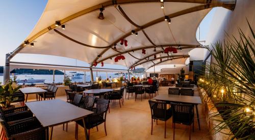 a restaurant with tables and chairs under a large umbrella at Marshal Hotel Heritage in Vis