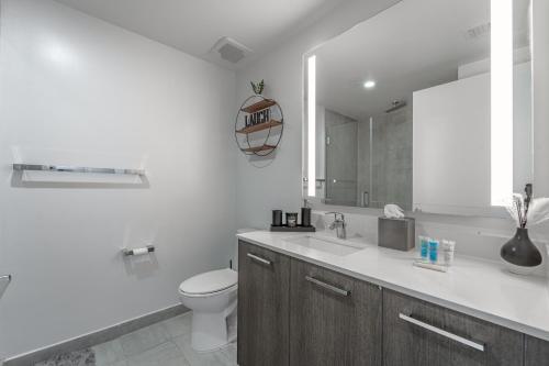 a white bathroom with a toilet and a sink at TR Miami 2 Bedroom, 1 Bedroom, and Studio Condos with Balconies in Miami