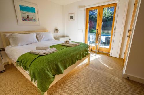 a bedroom with a bed with towels on it at House 28 in Looe