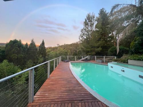a wooden bridge over a swimming pool on a house at RIVERLEA RETREAT MUDGEE - Private, Outdoor Bath, Pool, Tranquility in Apple Tree Flat