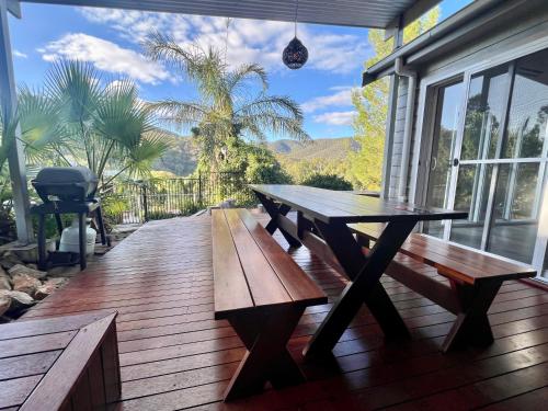 a picnic table on a deck with a grill at RIVERLEA RETREAT MUDGEE - Private, Outdoor Bath, Pool, Tranquility in Apple Tree Flat