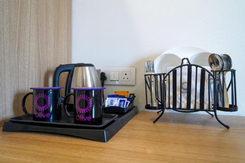 a tray with two coffee cups on a table at Olive Hotel Chikkamagalur by Embassy Group in Jāmb