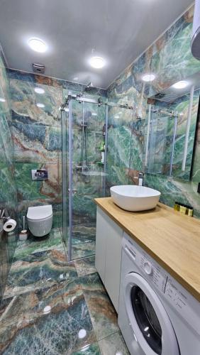 a bathroom with a sink and a washing machine at Bristol in Kvariati